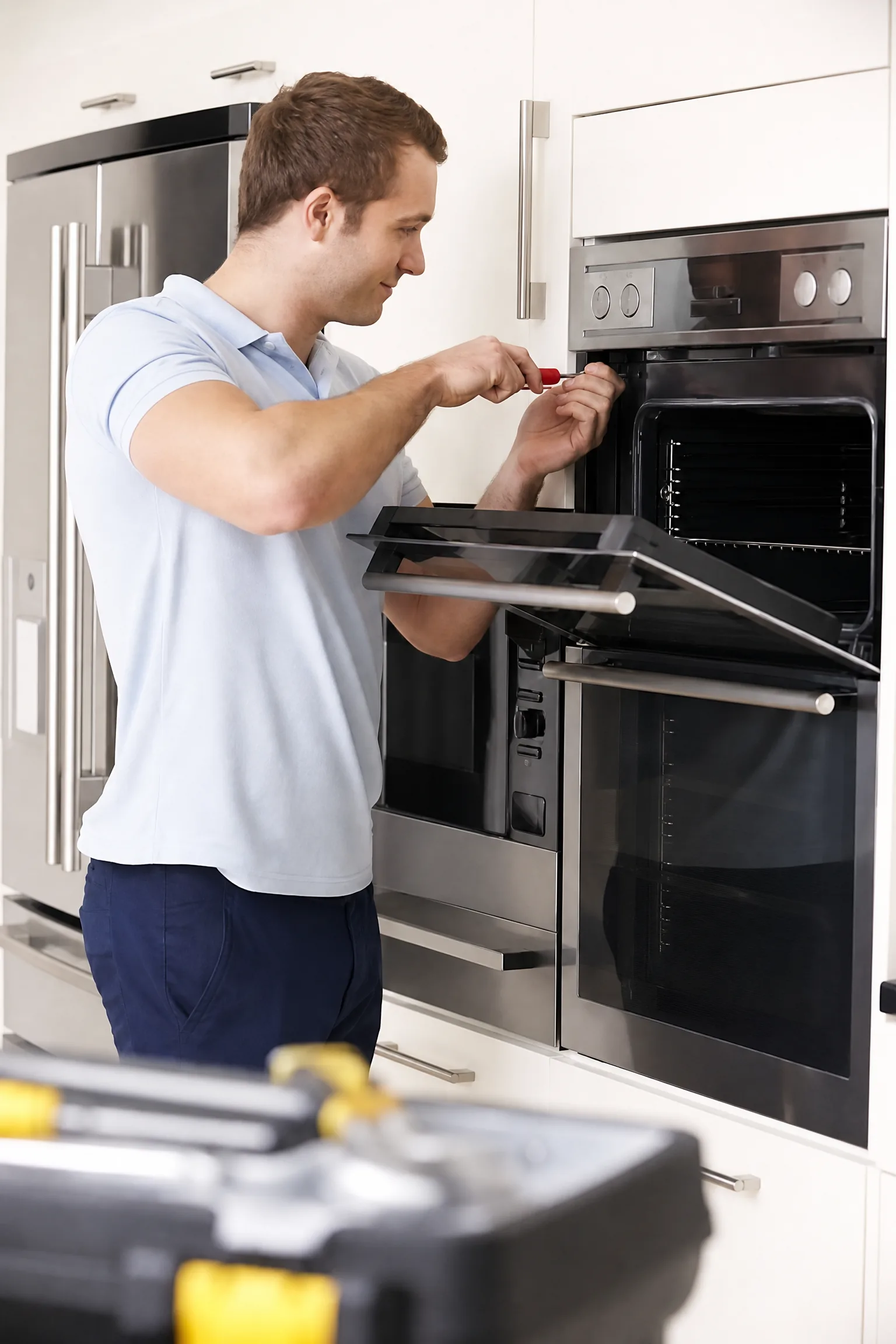 Technician servicing an oven in a modern kitchen