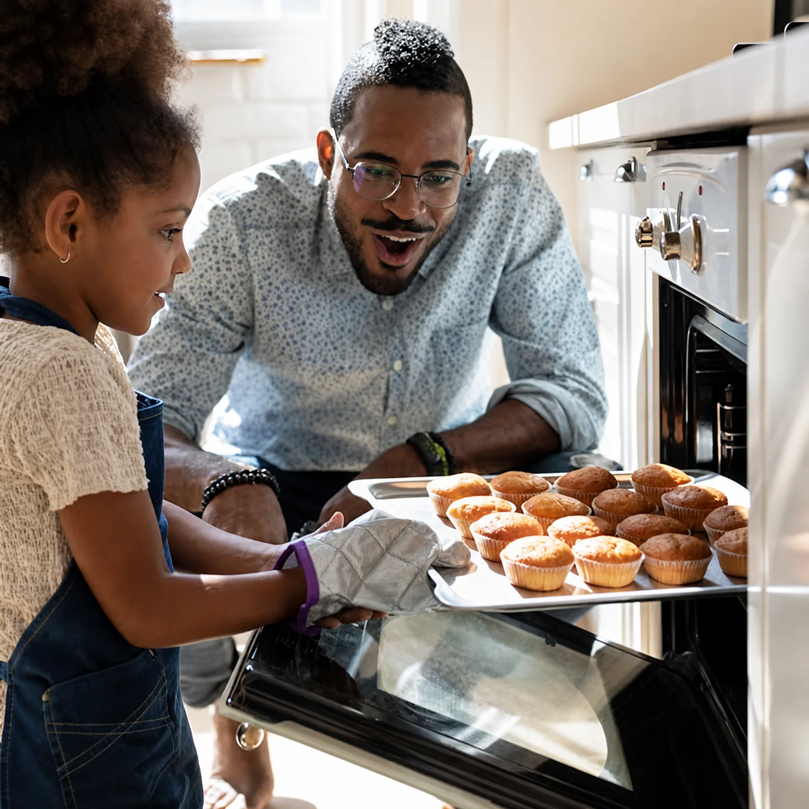 Family preparing food beside an open oven